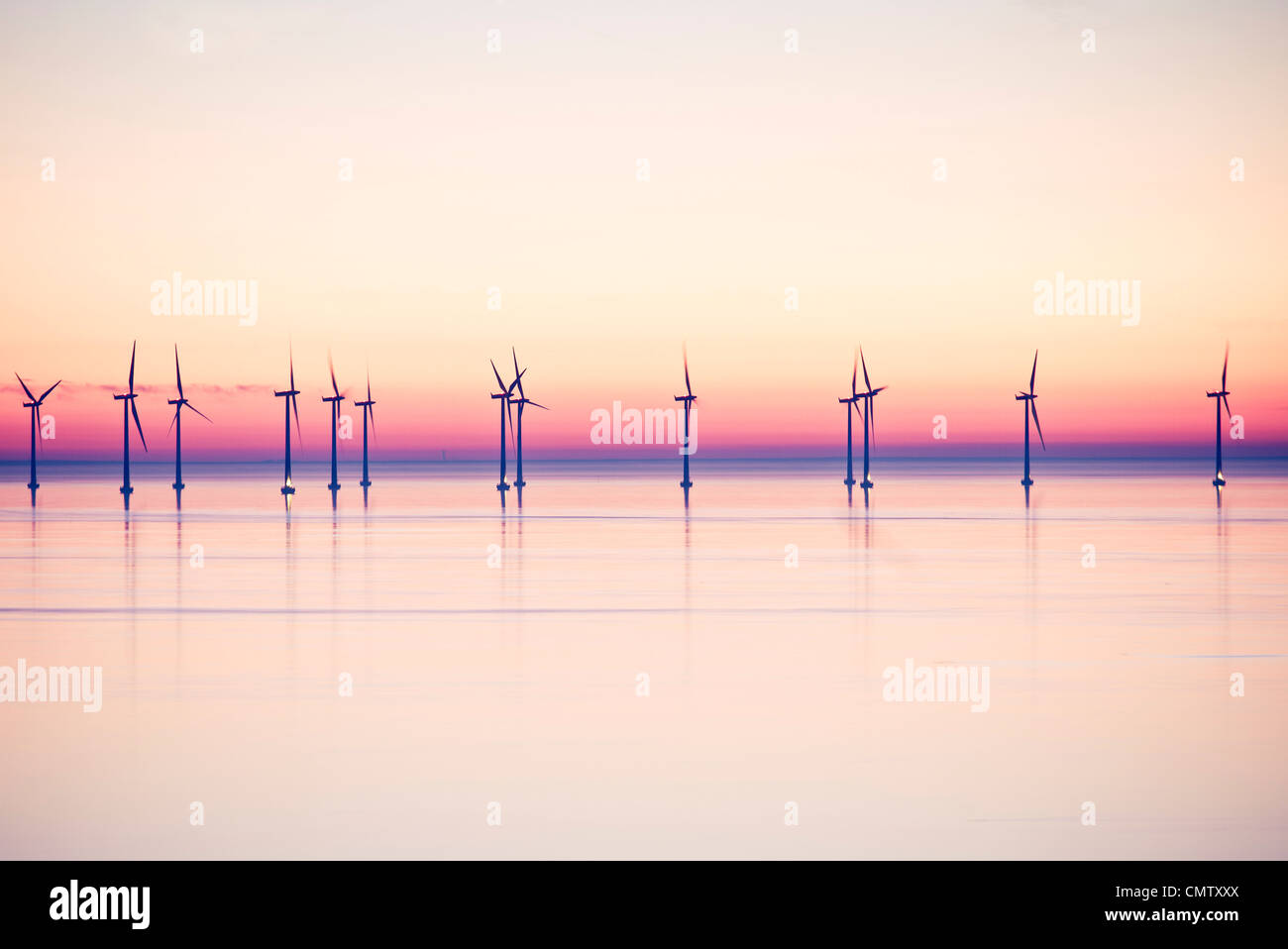 Wind power stations at sea in evening Stock Photo