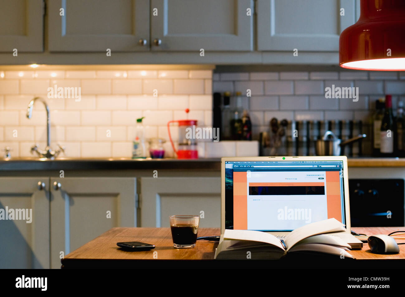 Laptop and book in kitchen Stock Photo