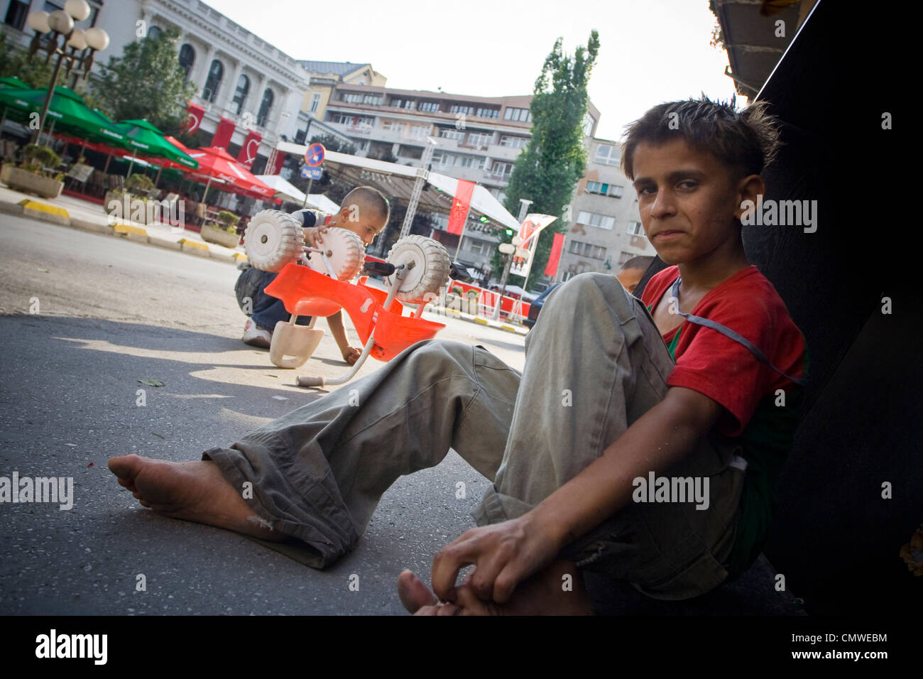 A Roma boys sits and begs on the street in Bosnian capital Sarajevo. Stock Photo