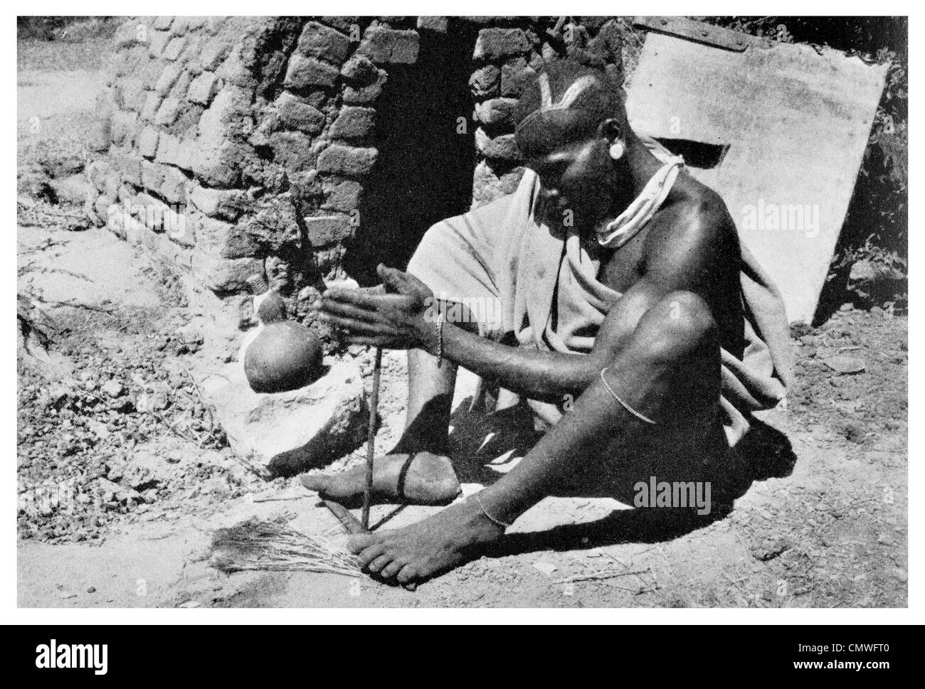 1925 Wakamba Native making fire with two sticks Kenya Colony Stock Photo