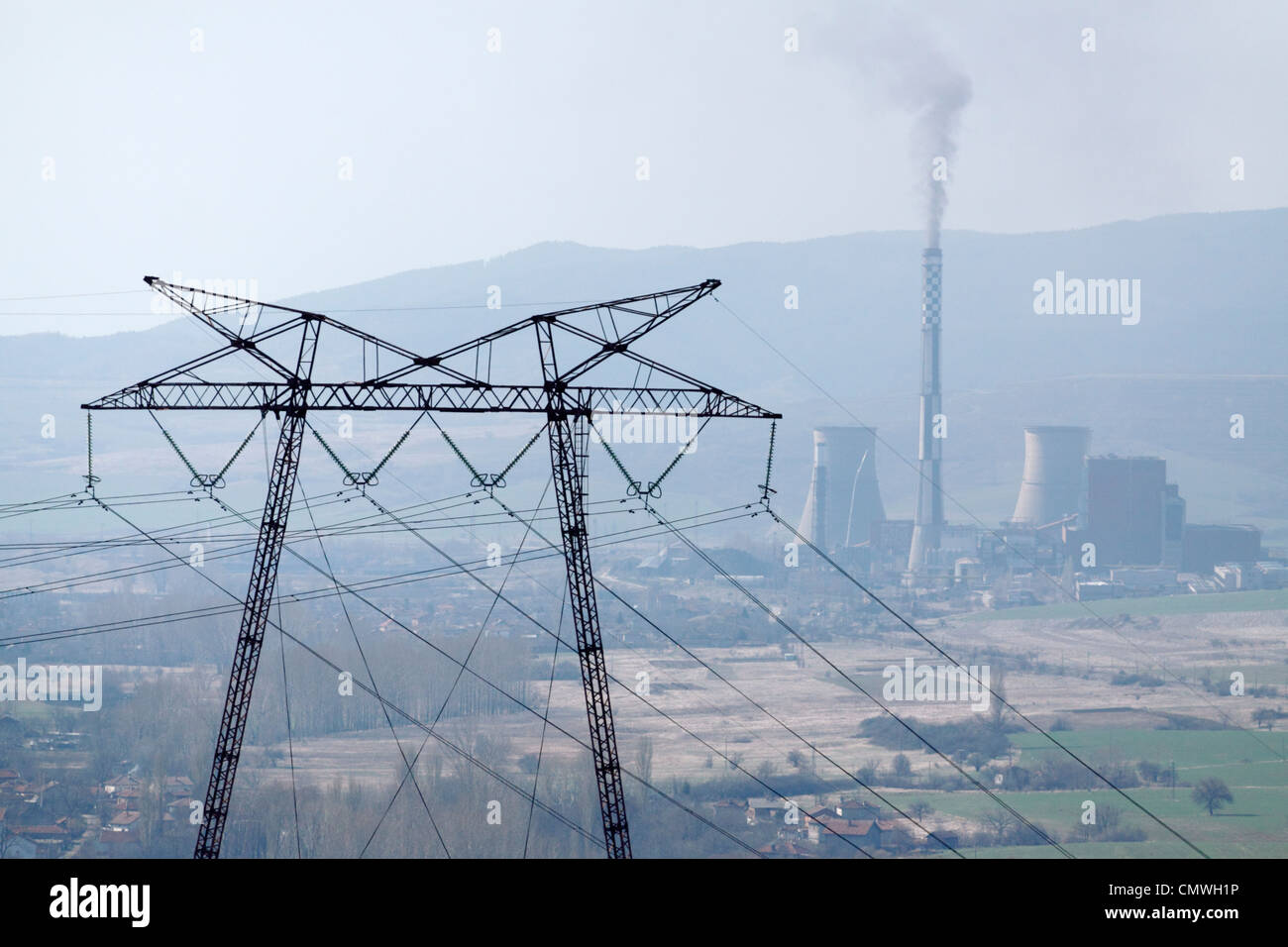 Coal-fired power plant Bobov Dol in western Bulgaria, black smoke coming out of chimney, seen behind an electric pylon Stock Photo