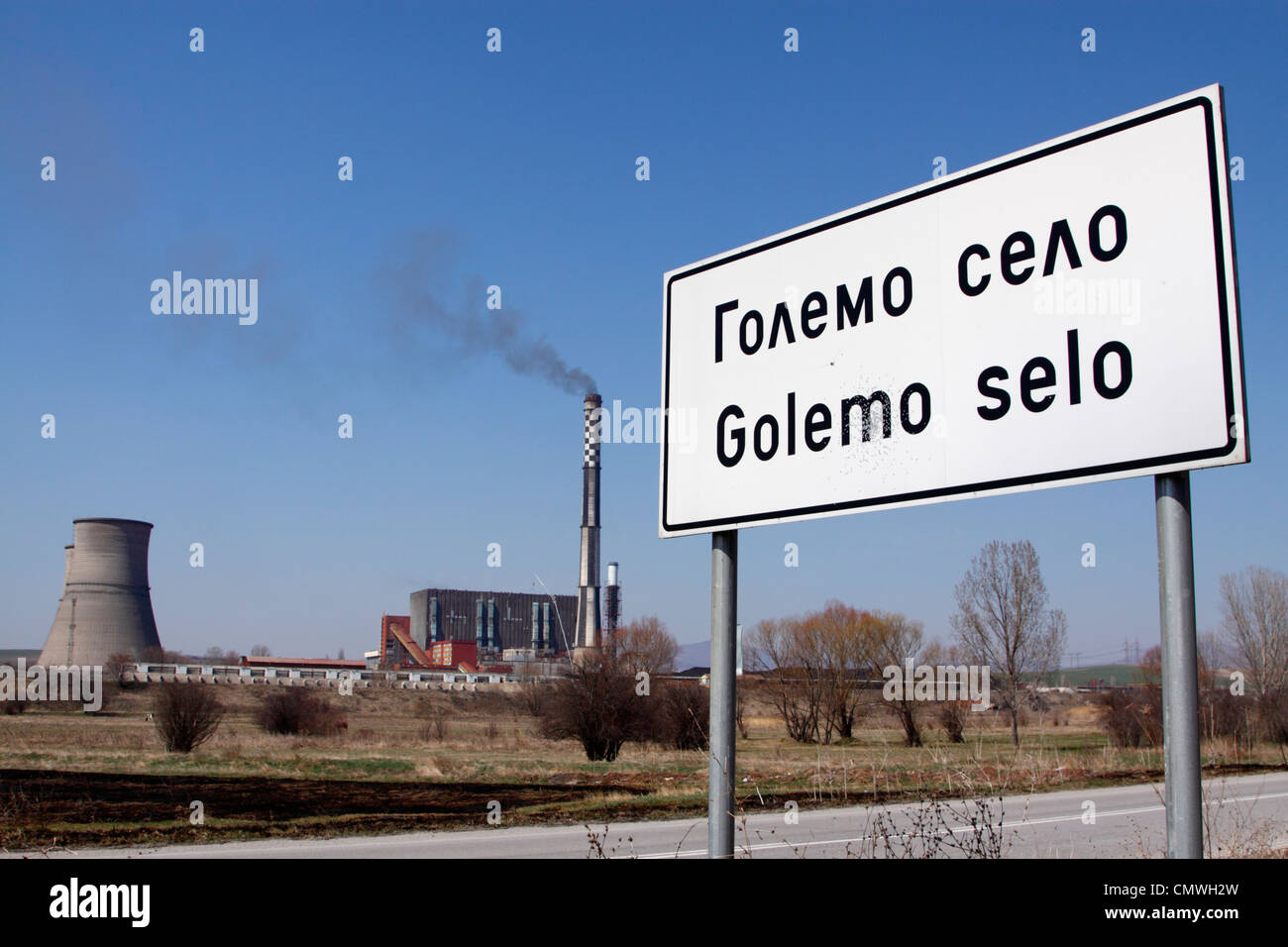 Signpost 'Golemo Selo' with the Bobov dol thermo-electric power plant in the background, black smoke coming out of the chimney Stock Photo