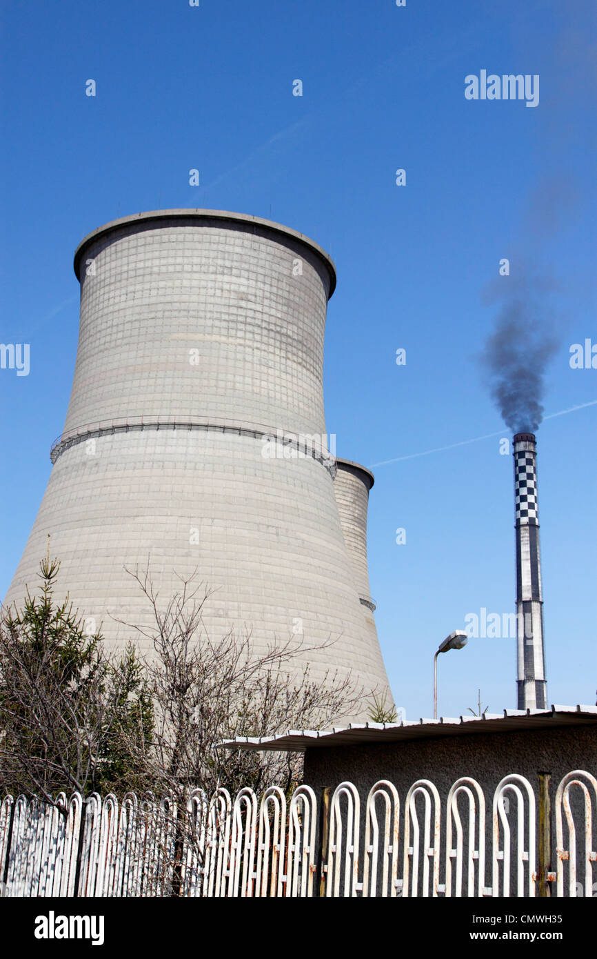 Cooling towers and chimney of Bobov Dol coal-fired power plant in western Bulgaria, black smoke coming out of the chimney Stock Photo