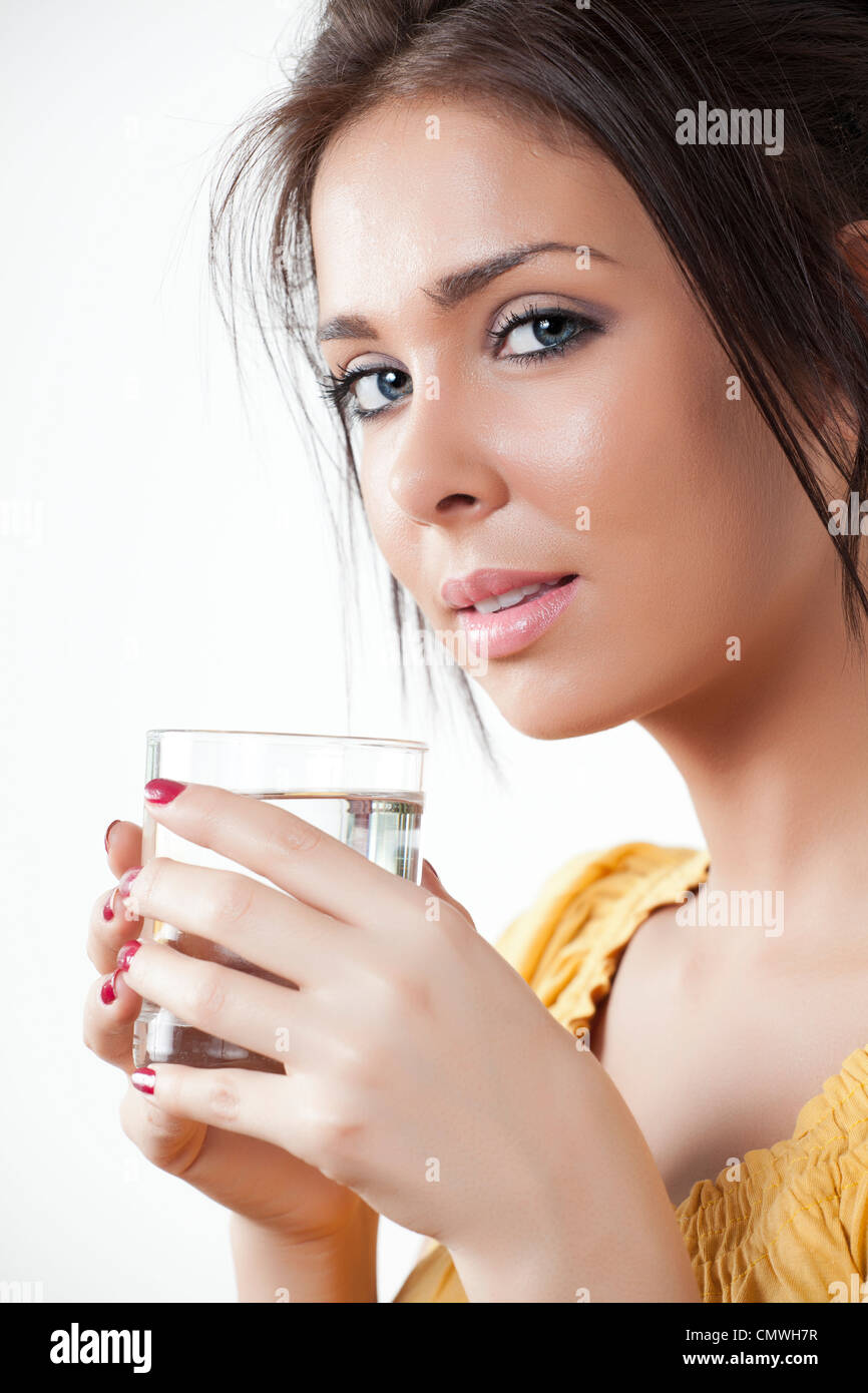 Young woman holding a glass of water and looking at the camera Stock ...