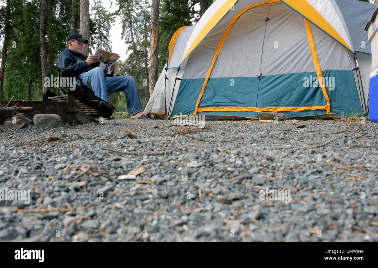 Camper beside his Tent, Prelude Lake Campground, outside Yellowknife, Northwest Territories Stock Photo