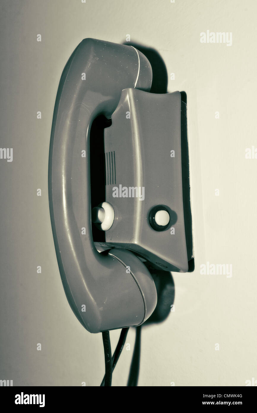 an old house phone hangs on the wall Stock Photo