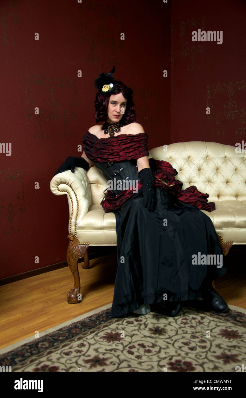 A lady dressed in victorian steampunk outfit on white couch Stock Photo ...