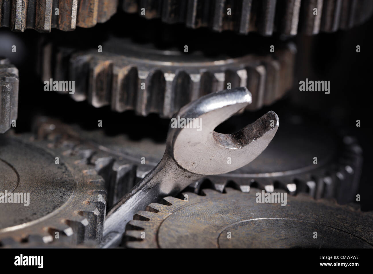 A Spanner Wrench stuck between cog gear wheels. Stock Photo