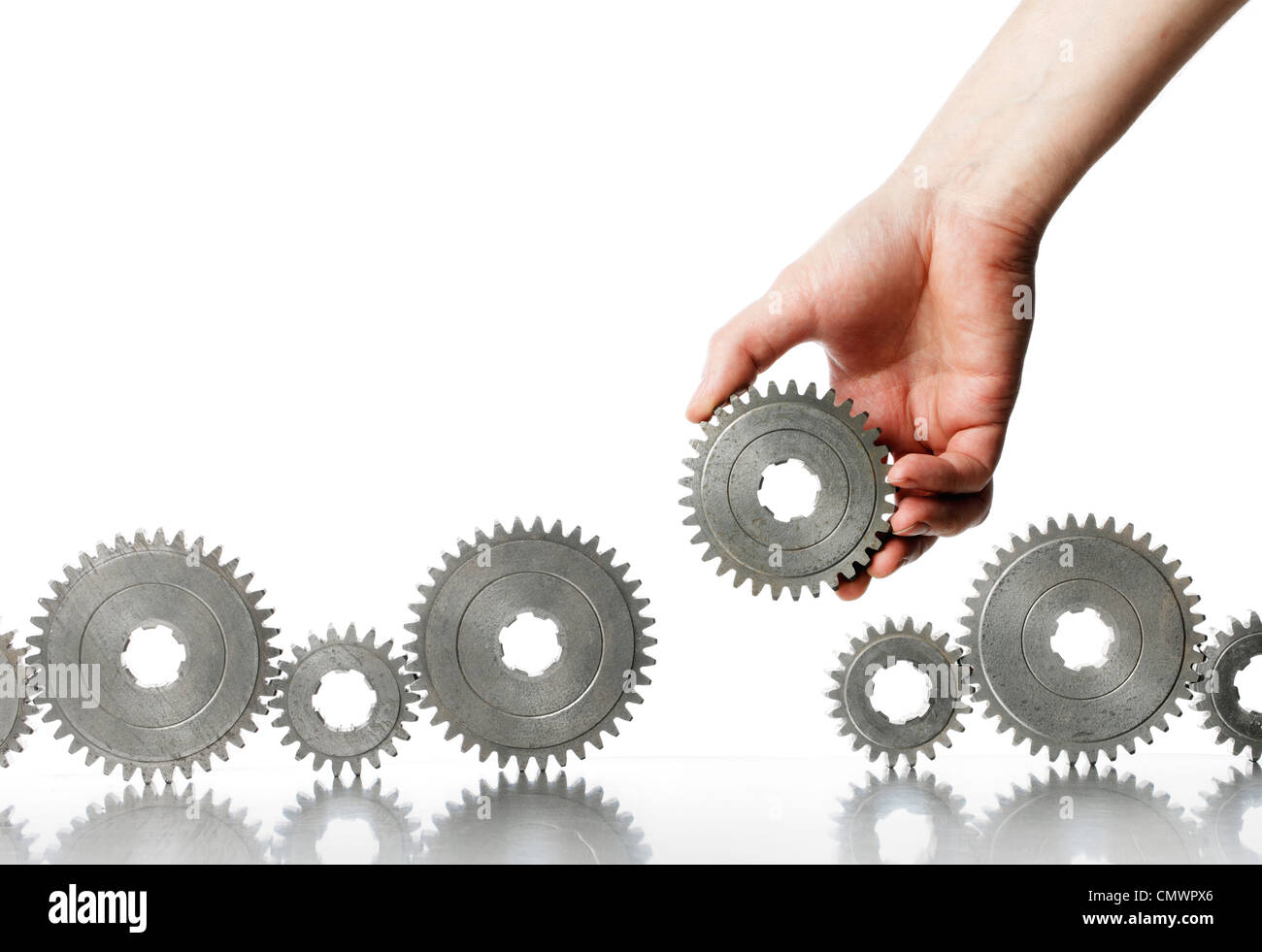 Man adding a cog gear wheel to a row. Stock Photo