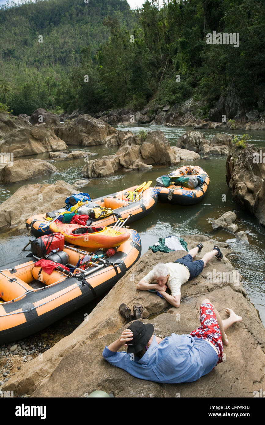 Rafters relaxing on riverbank during white water rafting expedition.  Wooroonooran National Park, Queensland, Australia Stock Photo