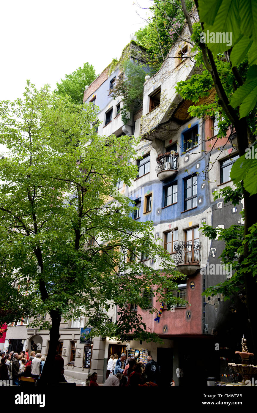 Green trees surrounding the facade of the Friedensreich Hundertwasser building. Stock Photo