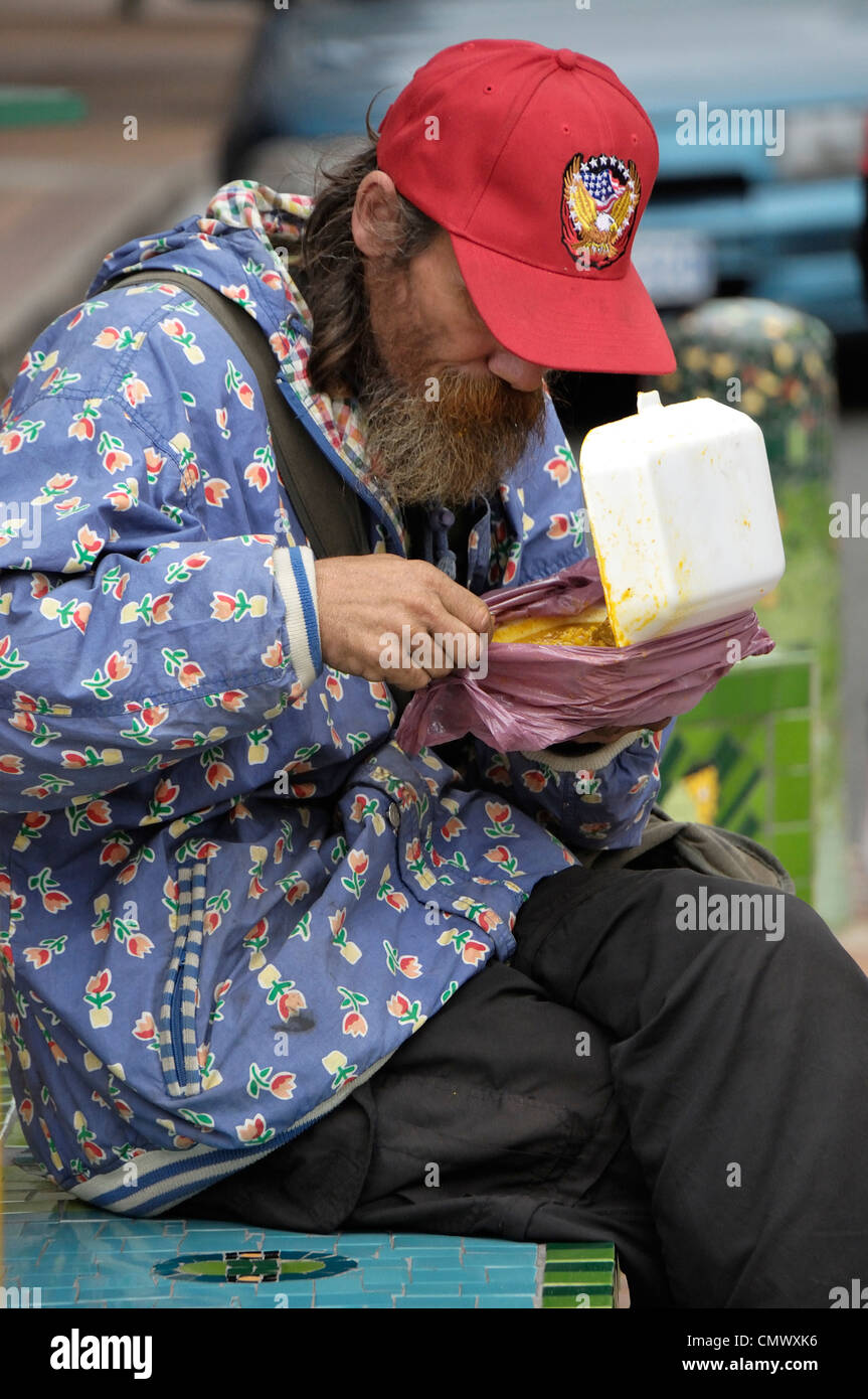 Durban homeless man eating his lunch in West Street Stock Photo