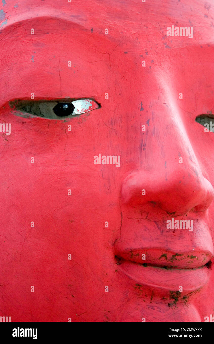 The beautiful red face of a large Buddha statue is on display at a Buddhist temple in Luang Prabang, Laos. Stock Photo