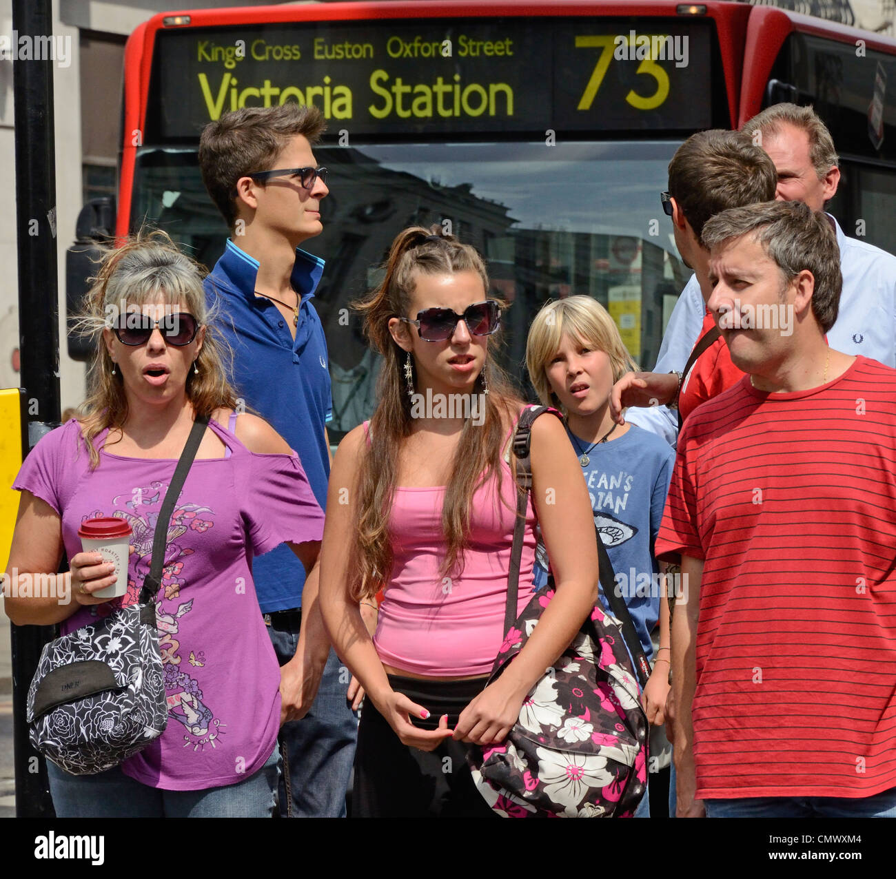 London, England. people waiting to cross street / red bus Stock Photo