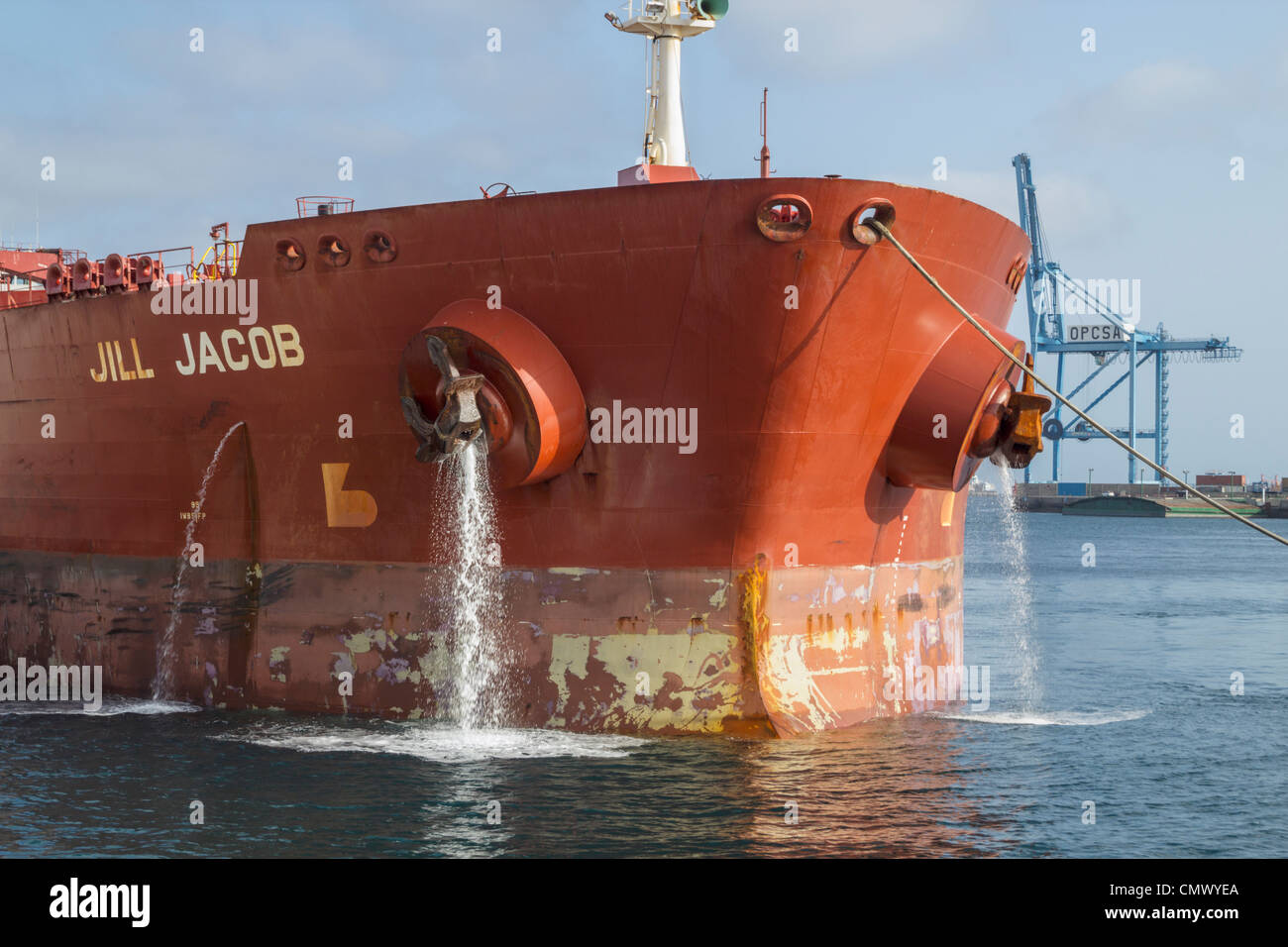 Oil tanker emptying ballast water as it arrives in port Stock Photo
