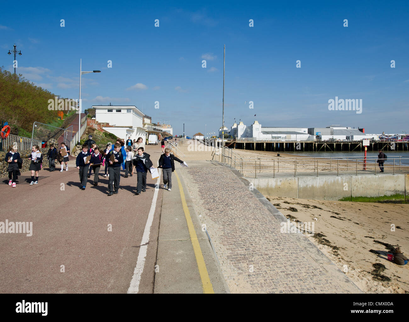 A group of school children walking along the promenade at Cacton in ...