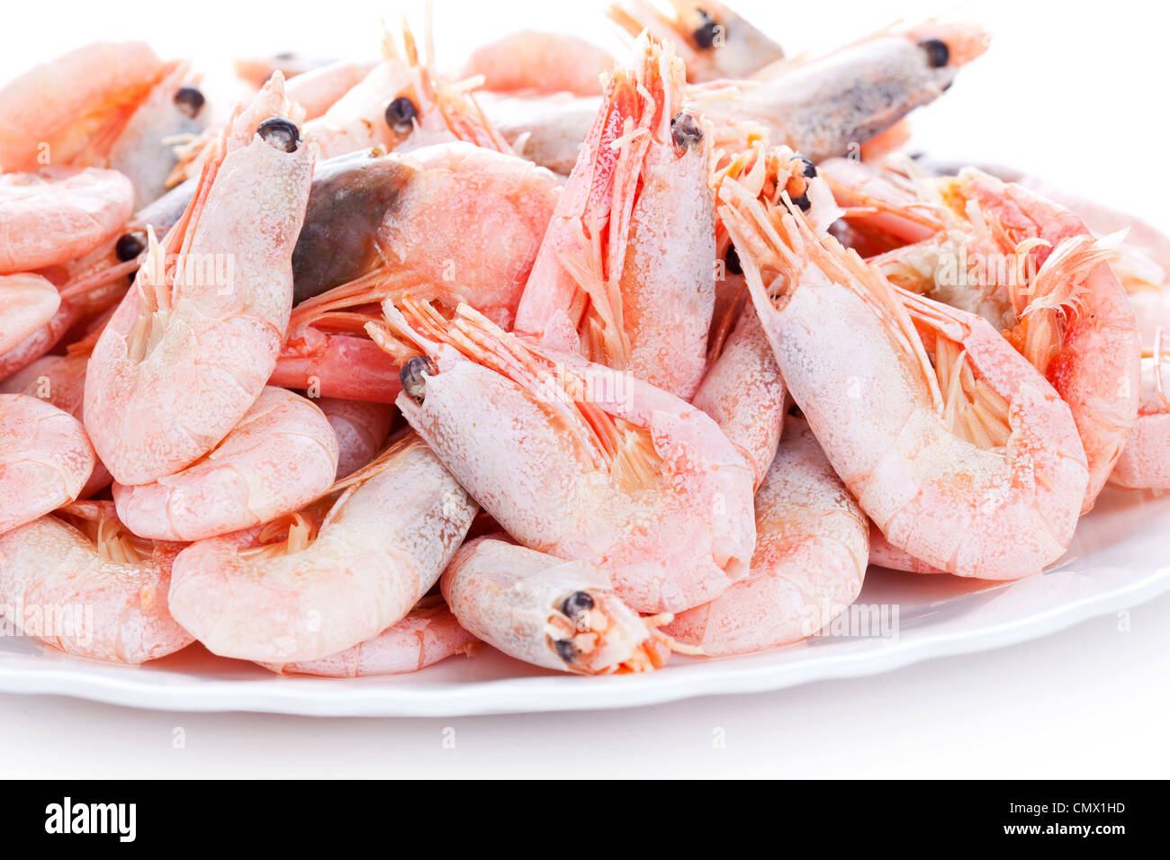 Pile of shrimps on plate, closeup on white background Stock Photo