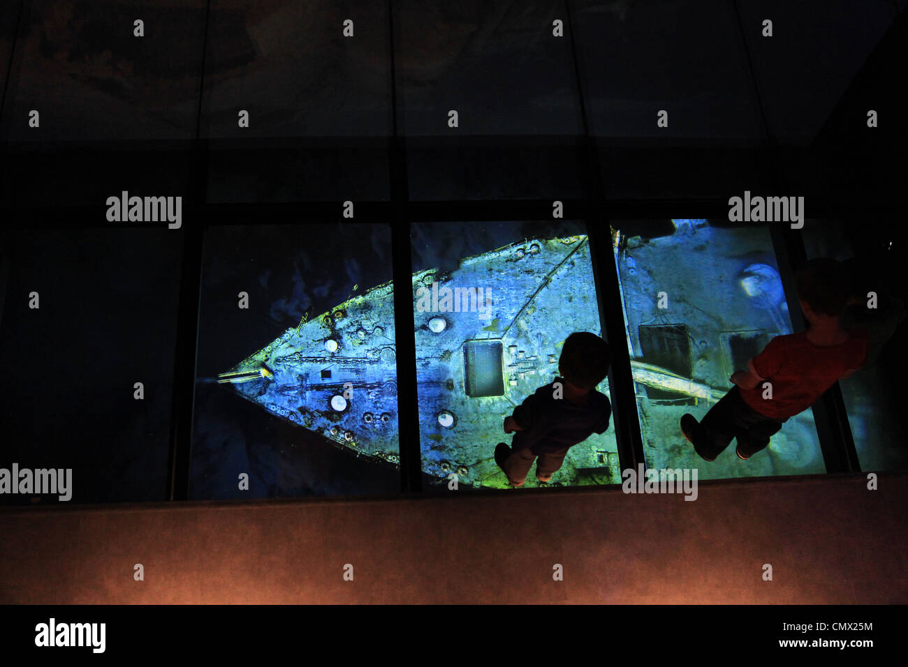 Children look down on a projection showing an image of the Titanic wreck on the seabed at the Titanic Belfast visitor Centre Stock Photo