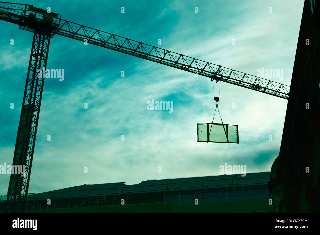 Crane lifting glass door into building under renovation Stock Photo Alamy