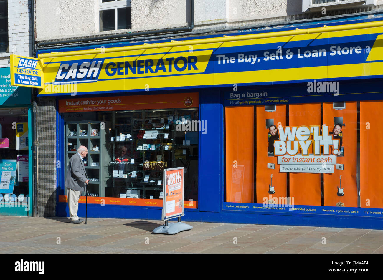 Man looking at the window display of Cash Generator, Dalton Road,  Barrow-in-Furness, Cumbria, England UK Stock Photo