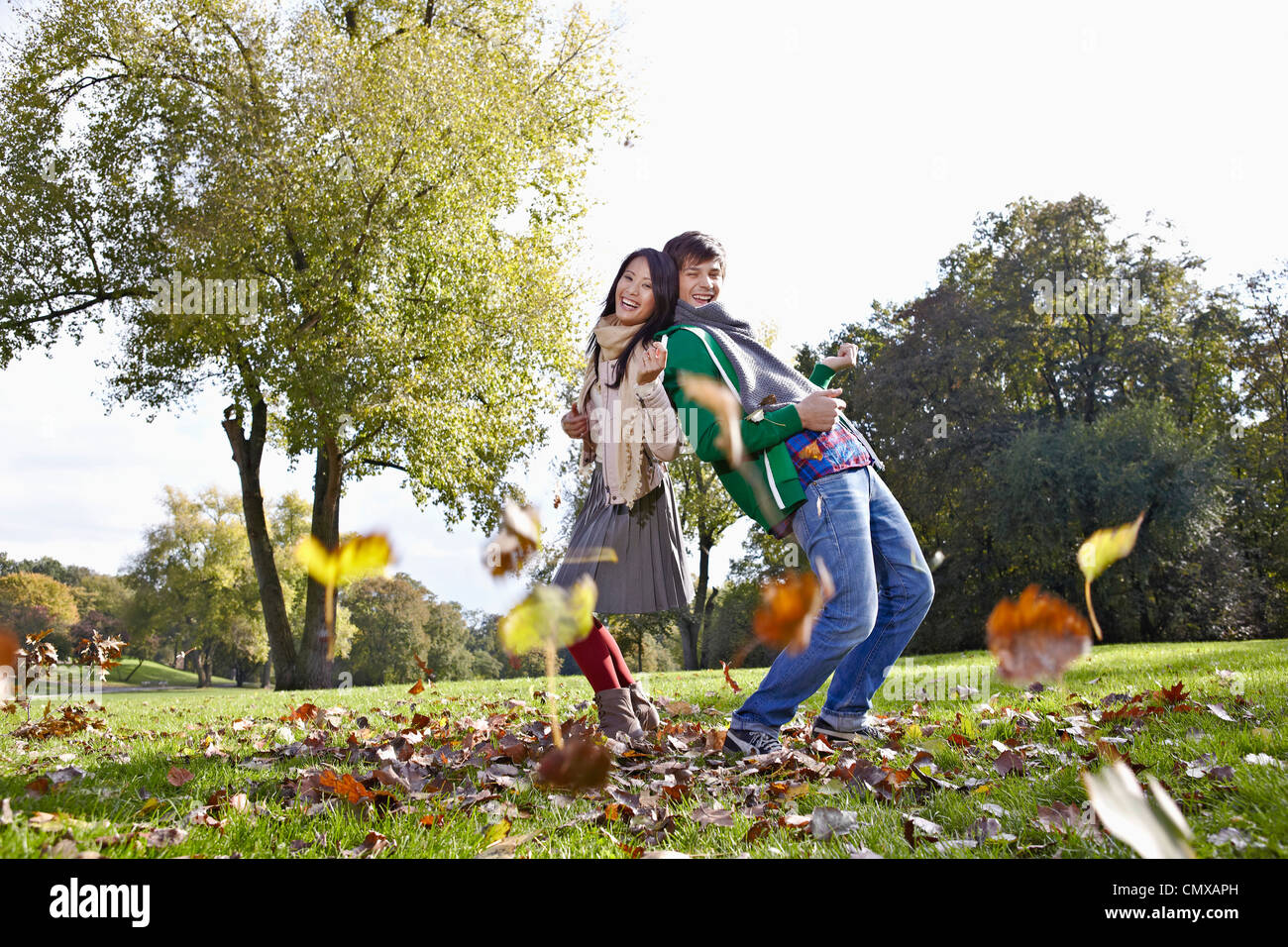 Germany, Cologne, Young couple in park, smiling, portrait Stock Photo