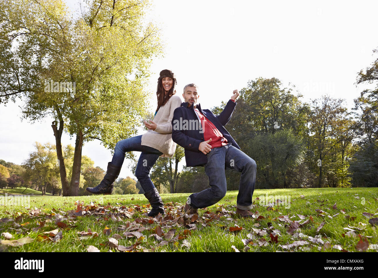 Germany, Cologne, Couple playing in park, smiling, portrait Stock Photo