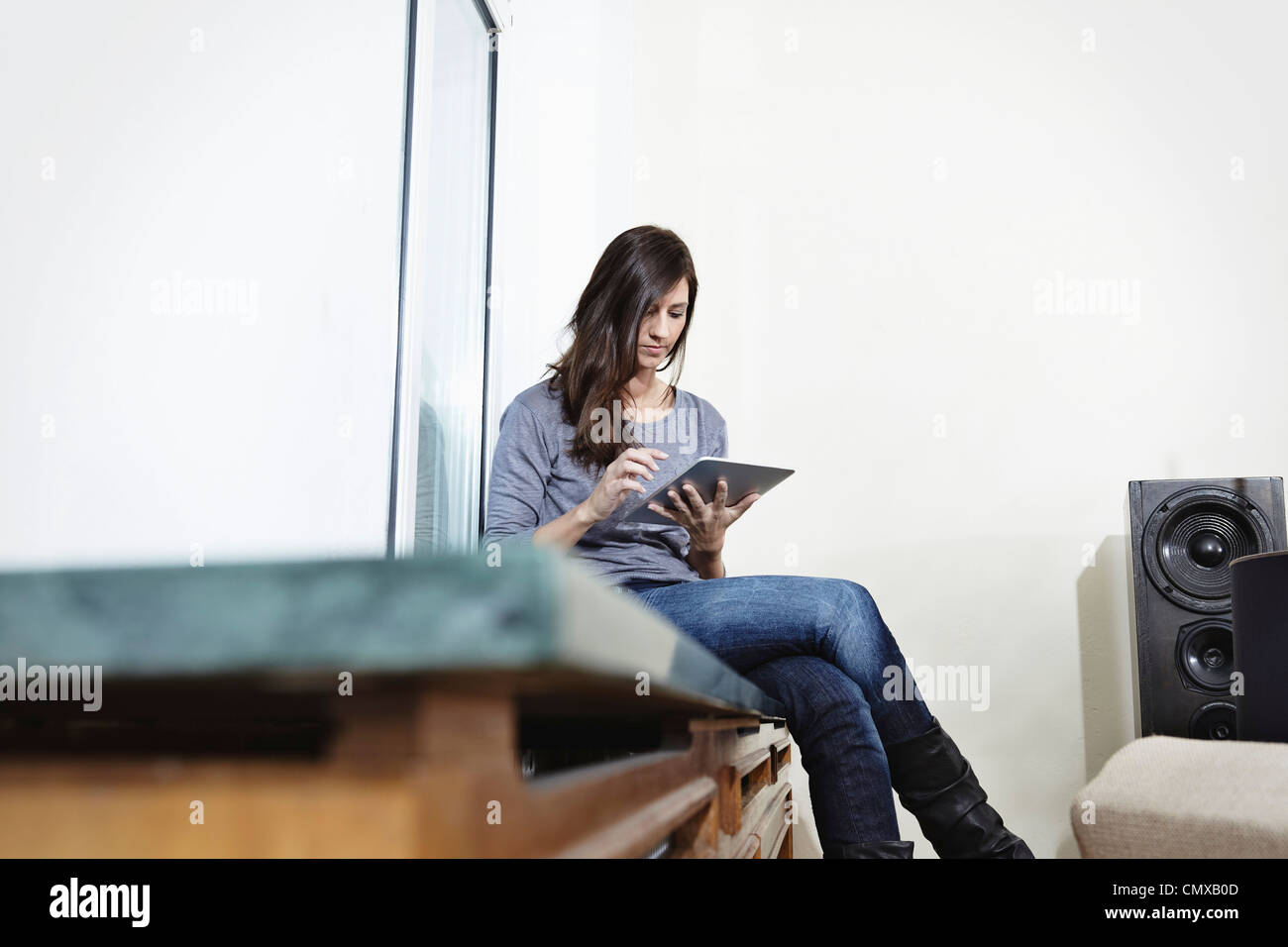 Germany, Cologne, Mid adult woman using digital tablet Stock Photo