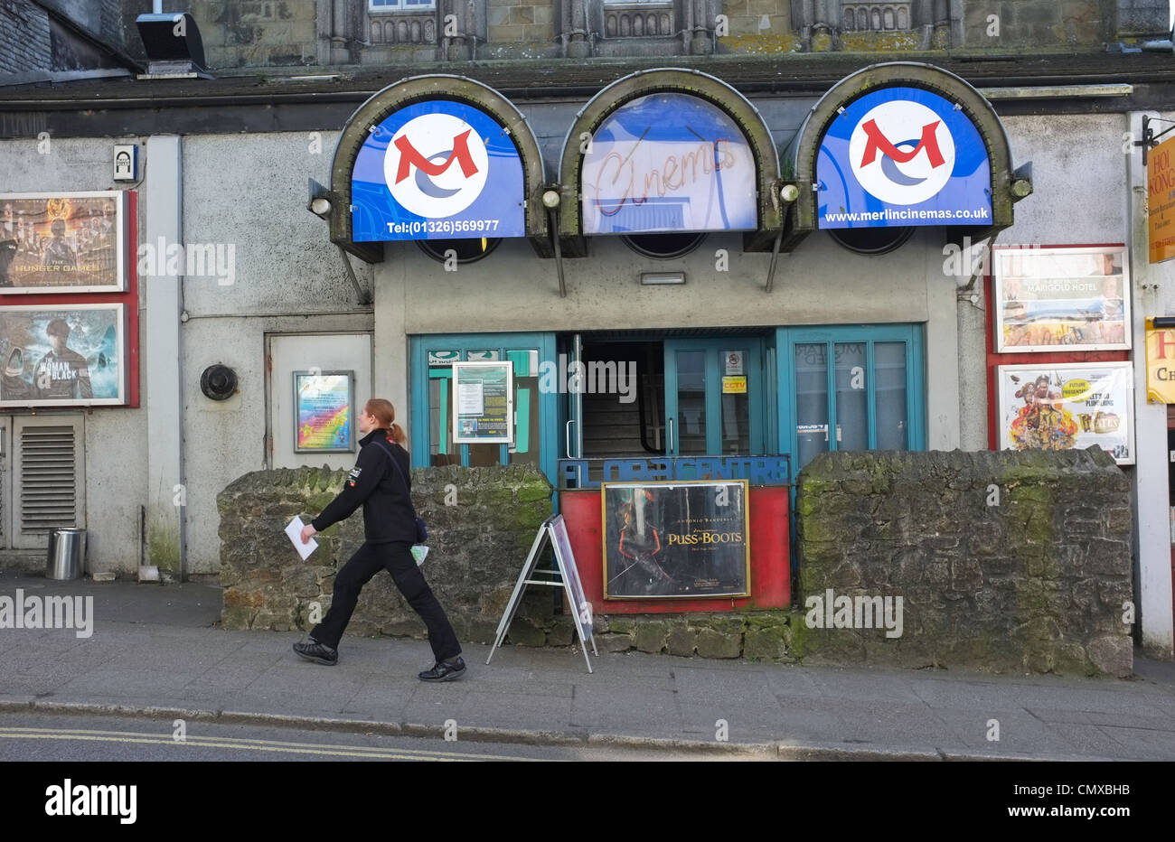 A woman walks past the Merlin Cinema in Helston, Cornwall Stock Photo