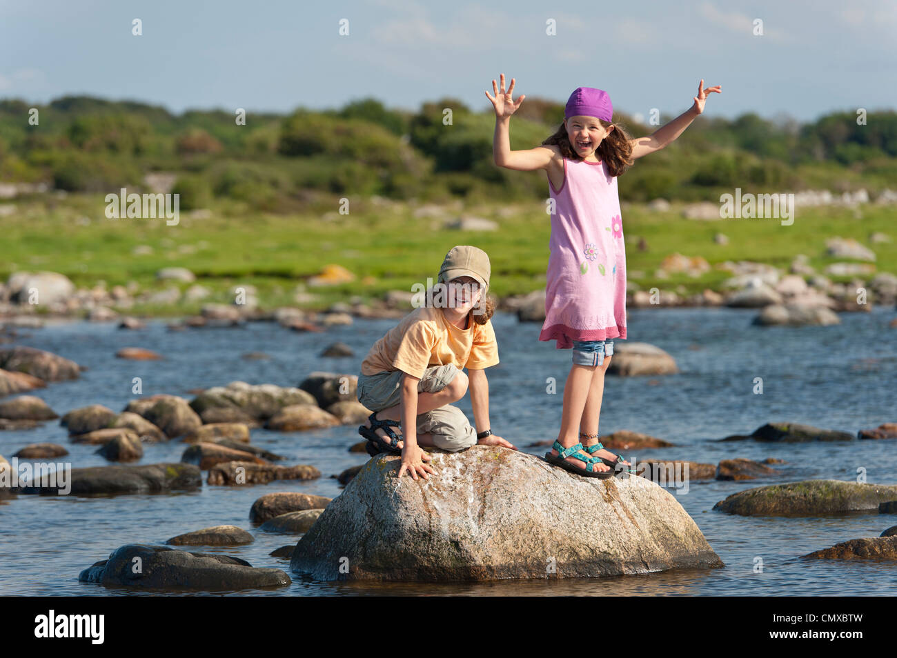 Sweden, Molle, Children balancing on rock in water Stock Photo - Alamy
