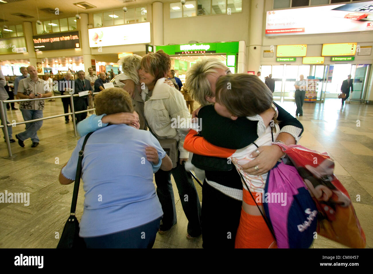 family reunited in the arrival area at Heathrow airport Stock Photo