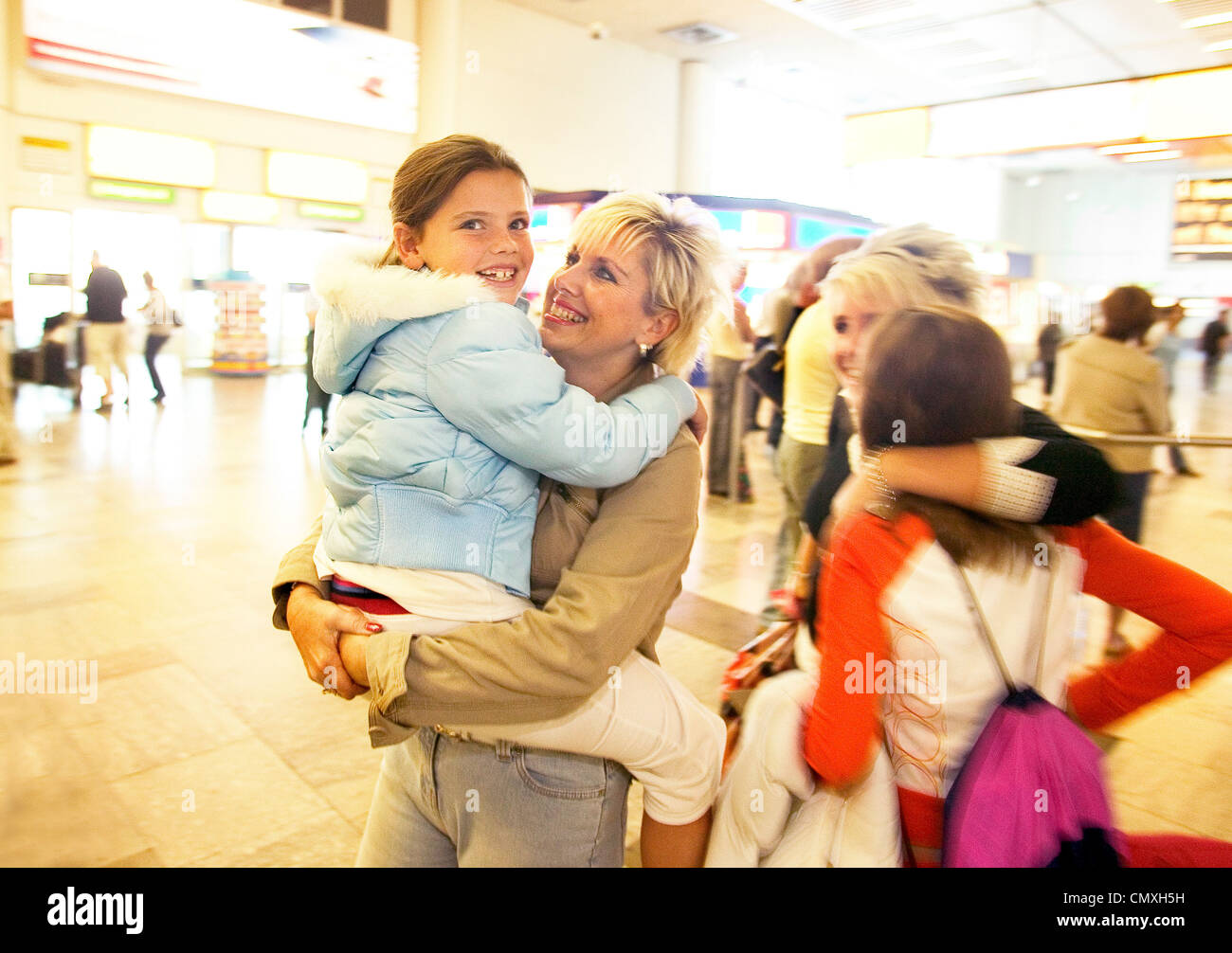 family reunited in the arrival area at Heathrow airport Stock Photo