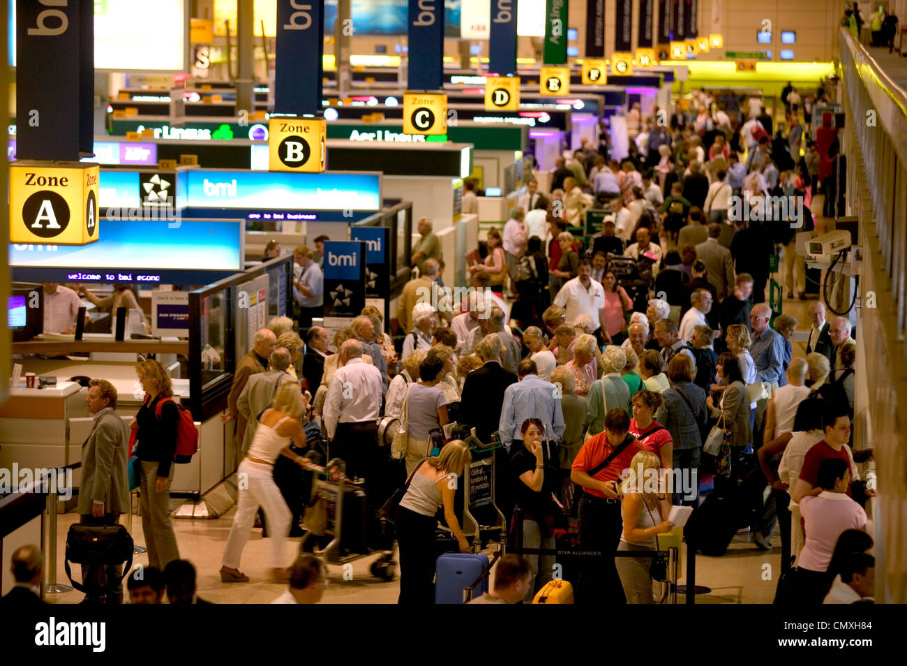 Check-in counters in busy departure lounge at Heathrow airport Stock Photo