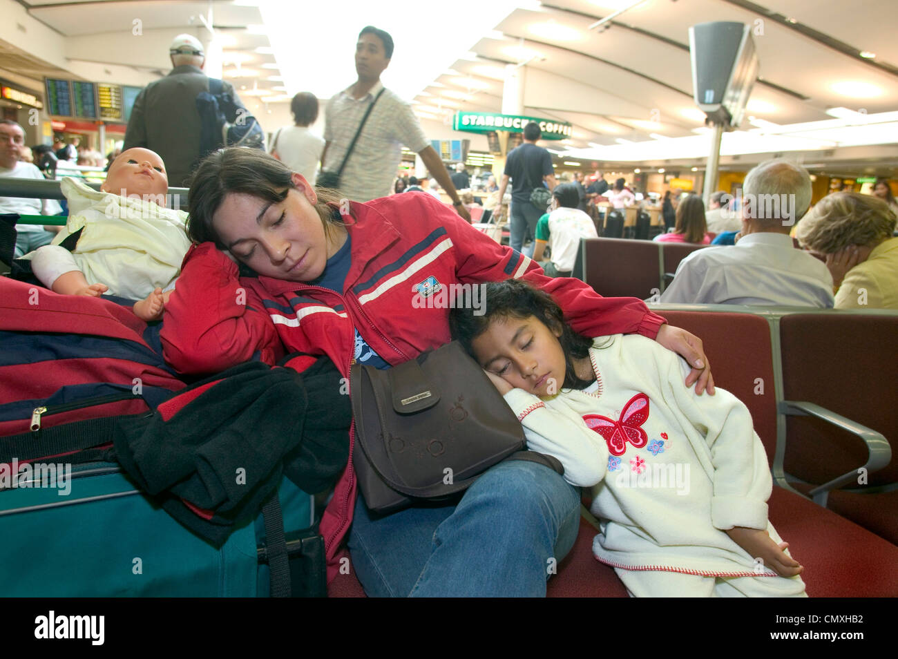 mother and daughter asleep in Heathrow airport departure lounge Stock Photo