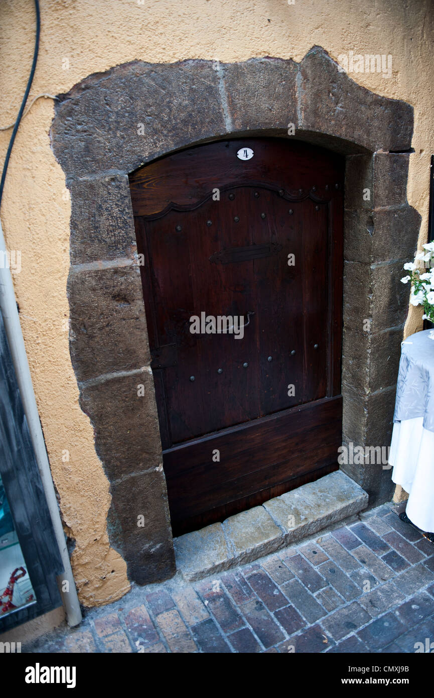 A small side door along a sidewalk outside of restaurant in France. Stock Photo