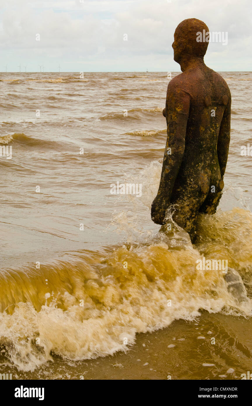 One of the 100 figures which make up Antony Gormley’s Another Place on the coast at Crosby Merseyside Stock Photo