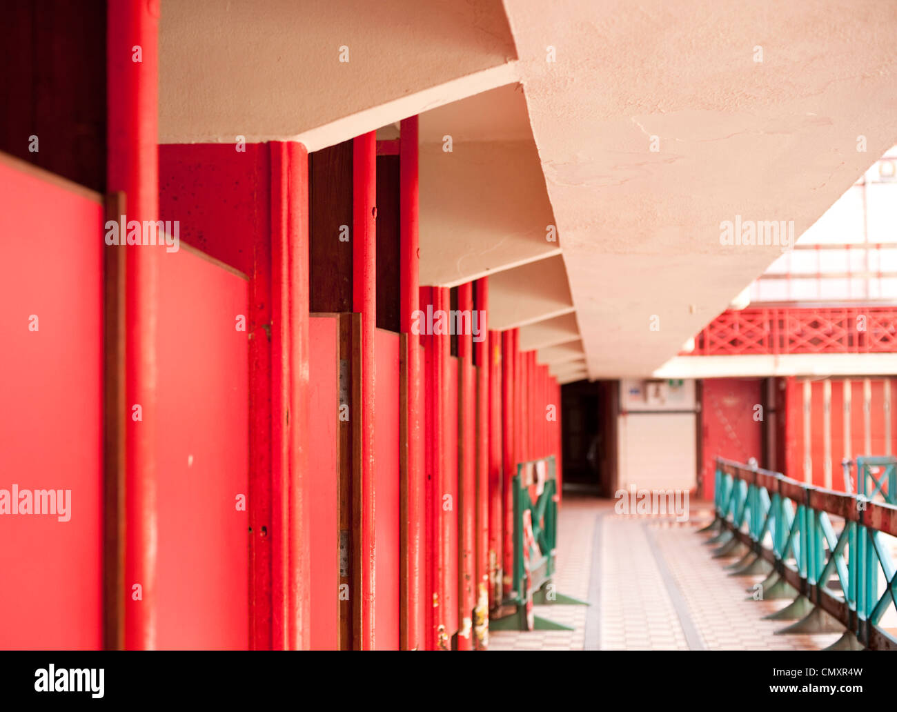 The corridor of doors to the red changing rooms beside the main swimming pool of Govanhill Baths in Glasgow Stock Photo