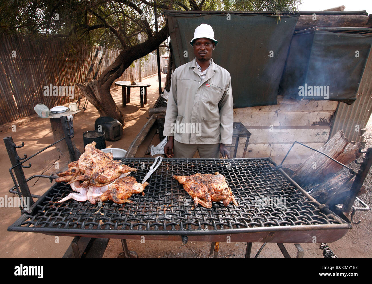 Man is selling a roast chicken on the street in a small town in RSA. Stock Photo