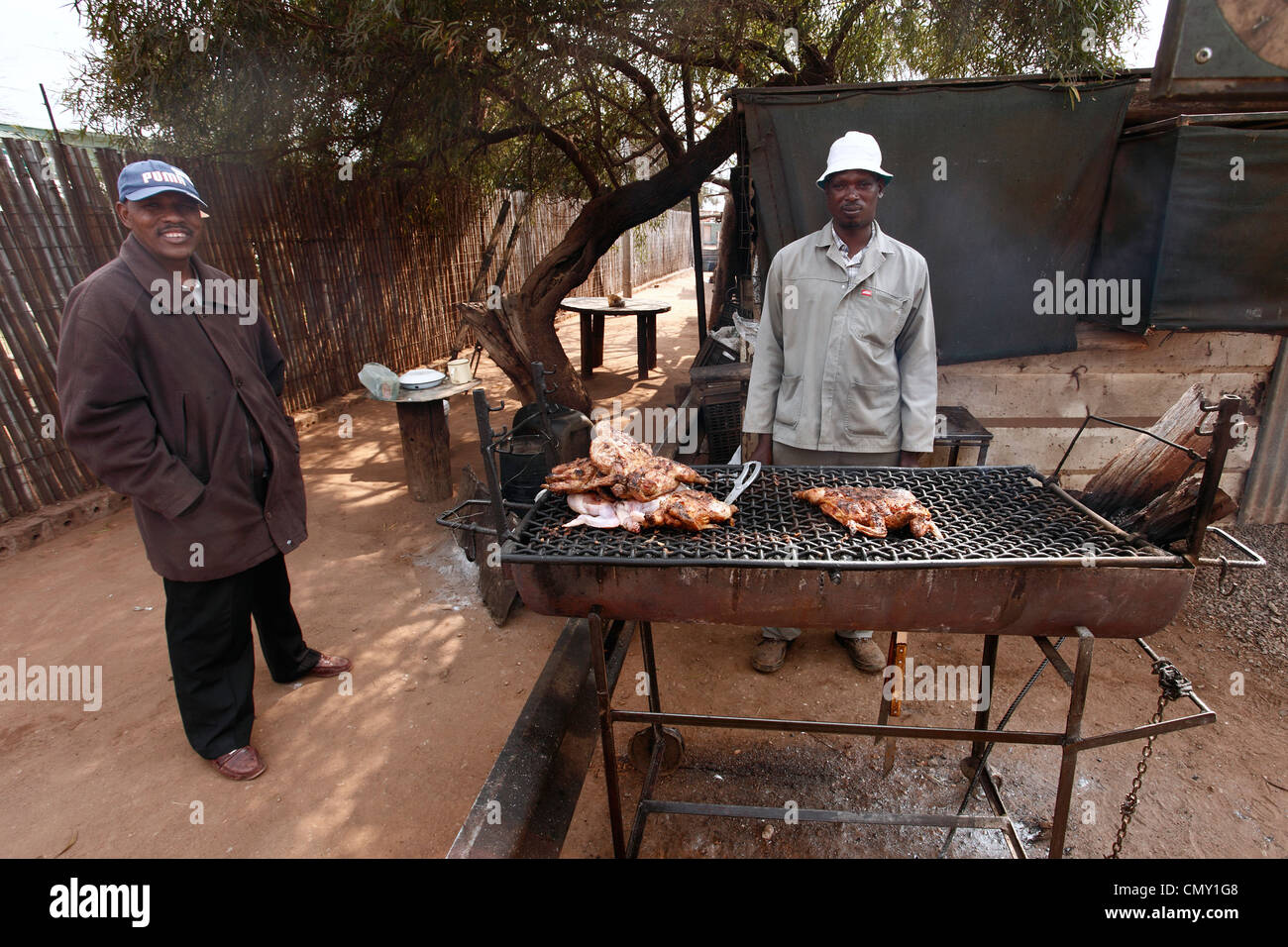 Man is selling a roast chicken on the street in a small town in RSA. Stock Photo