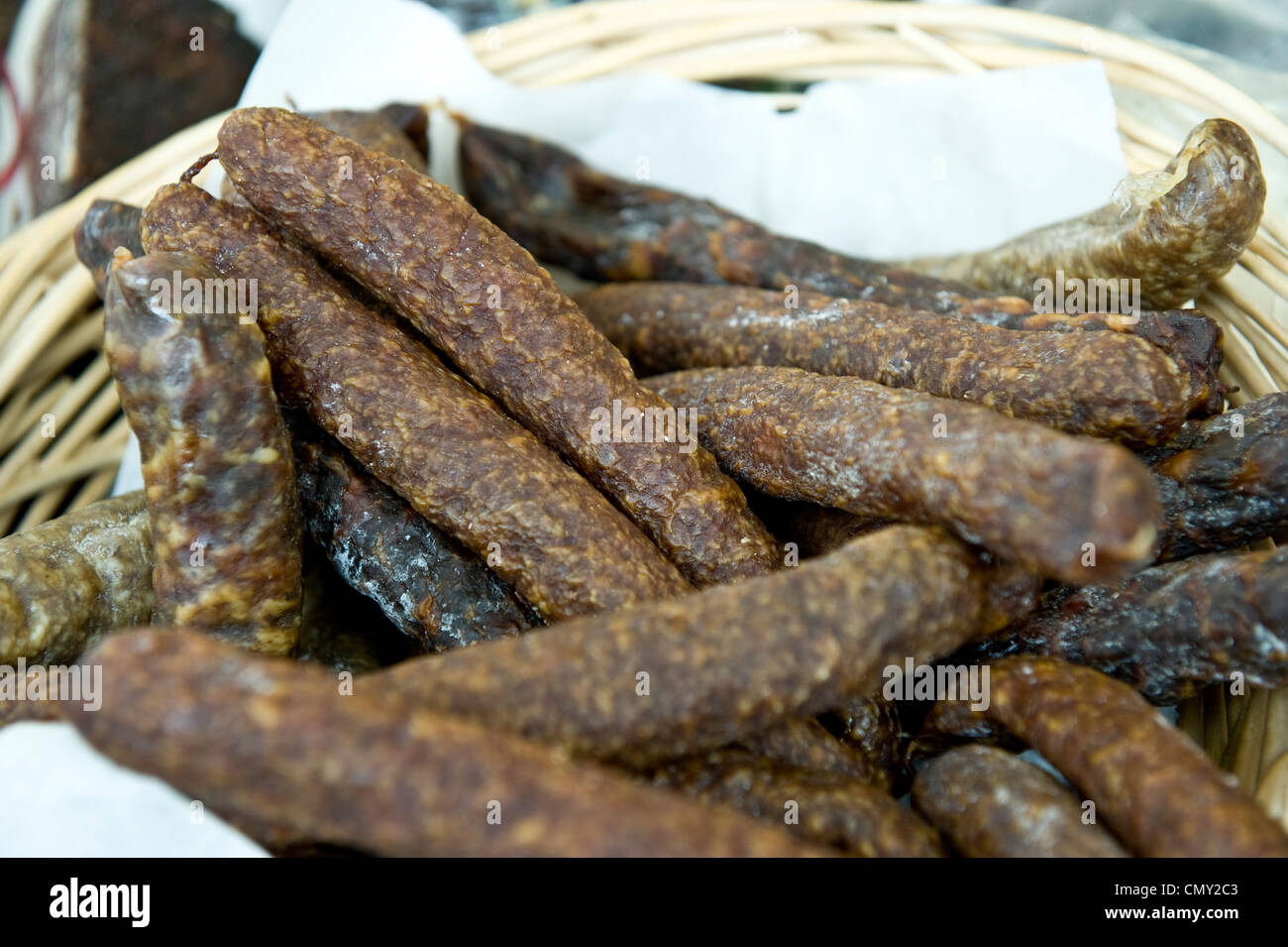 A closeup of dry salami in a wooden basket. Stock Photo