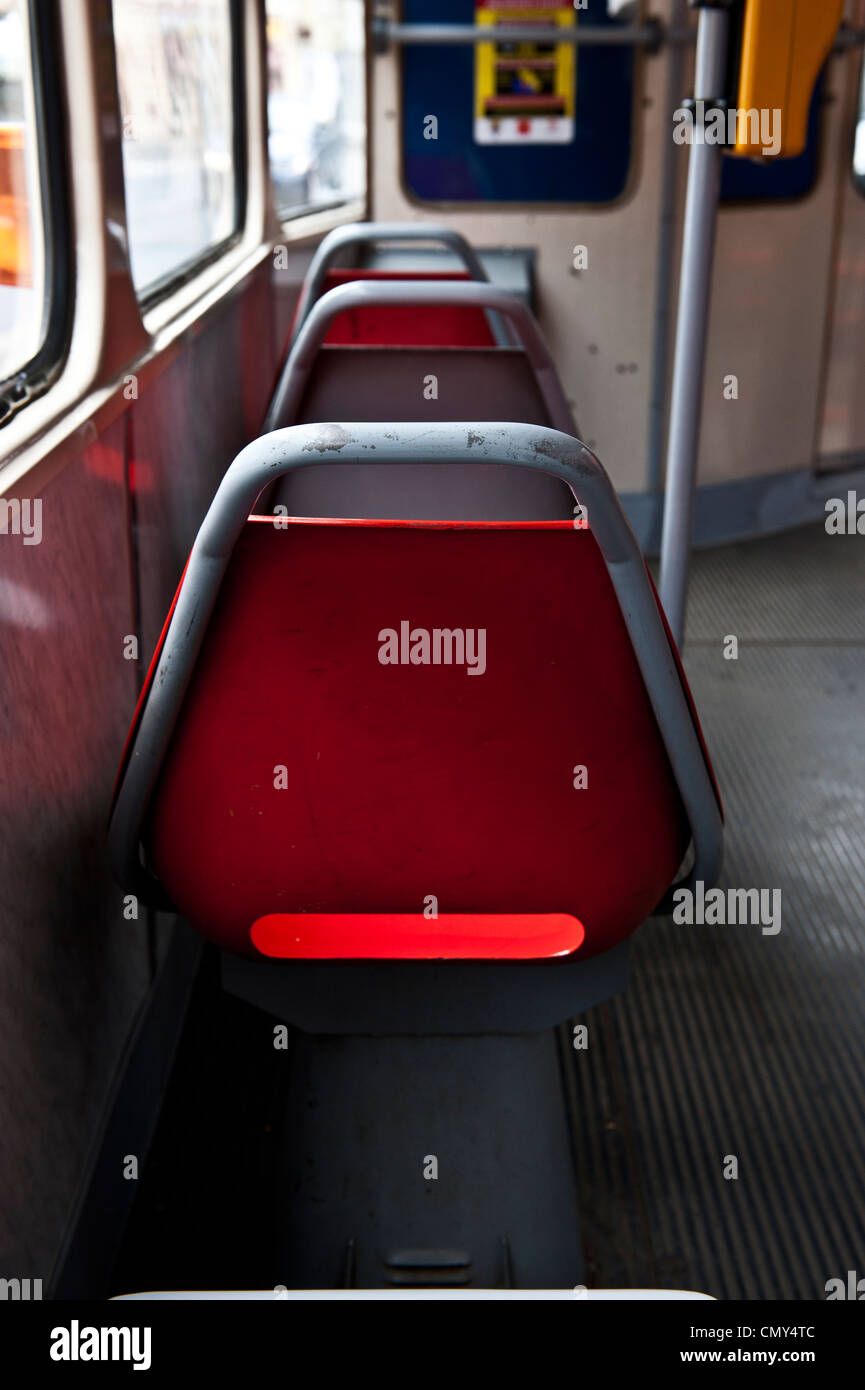 A red seat inside of a small European train. Stock Photo