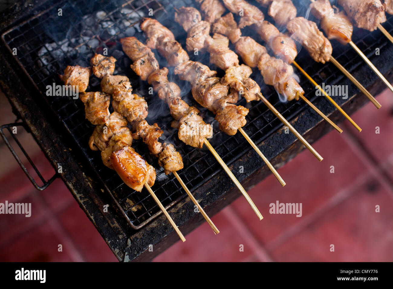 Pork skewers grill over charcoal at a barbeque in Antipolo, Rizal Province, Philippine Islands. Stock Photo