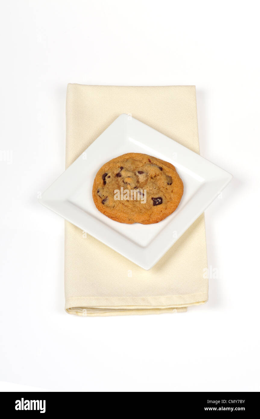 Single chocolate chip cookie on white plate cut out Stock Photo