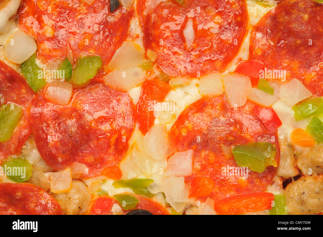 Macro close-up detail of pizza with cheese, pepperoni, sausage, red and green peppers, onions Stock Photo