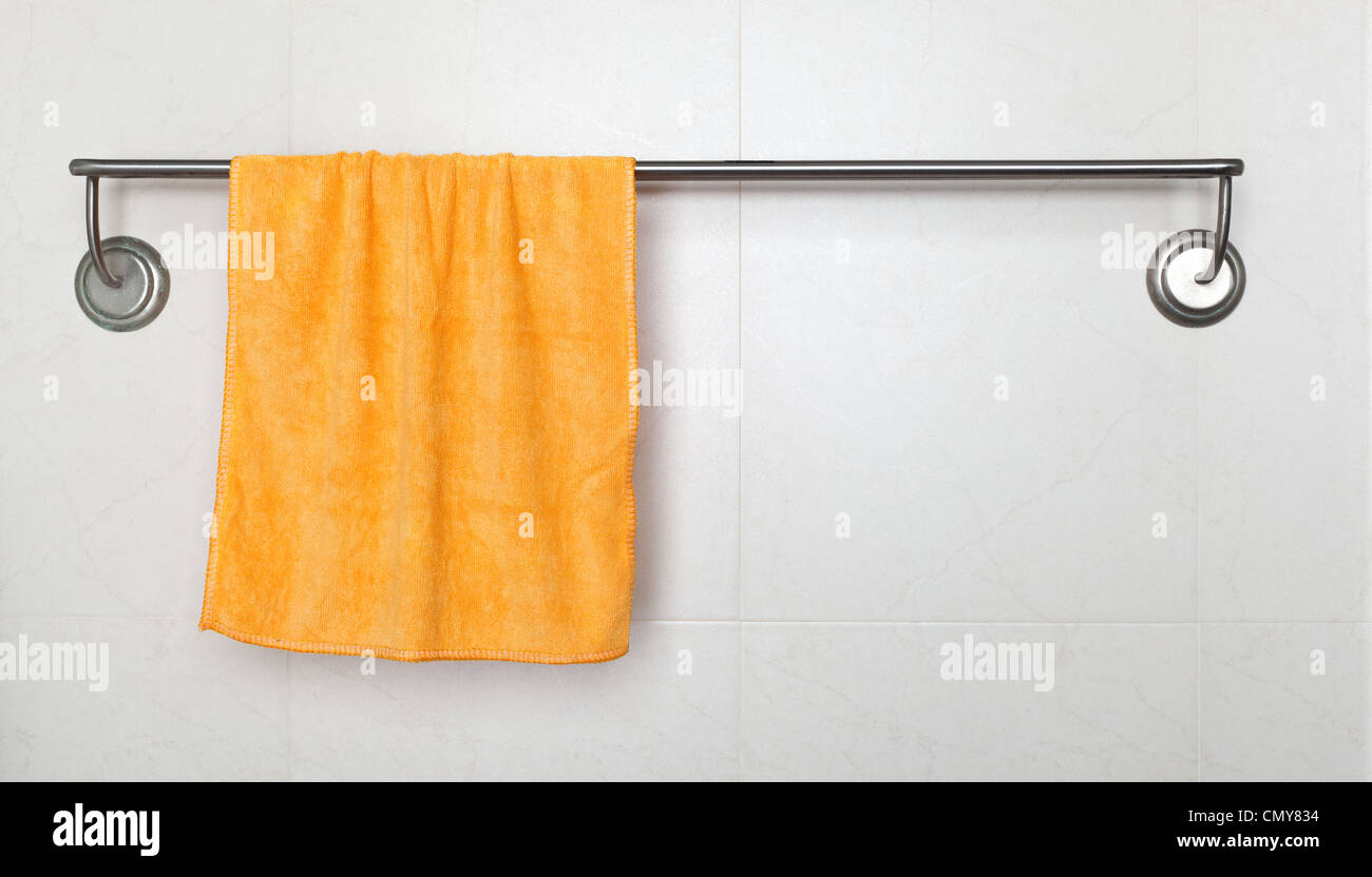Orange microfiber towel hanging on a rack in a bathroom Stock Photo