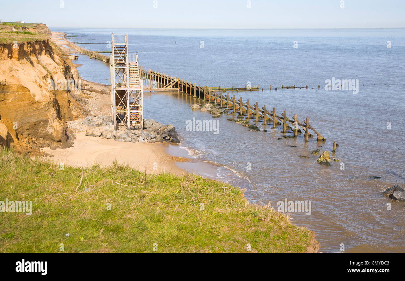 Rapid coastal erosion Happisburgh Norfolk England former beach access stairs now stand alone Stock Photo