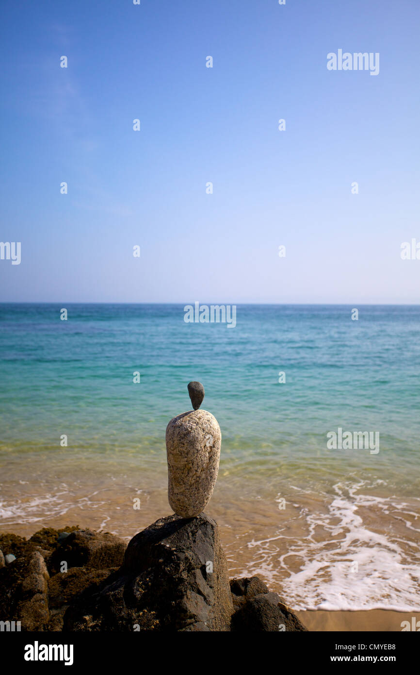 Stones balancing on top of each other on the beach in St.Ives, Cornwall with the sea in the background Stock Photo