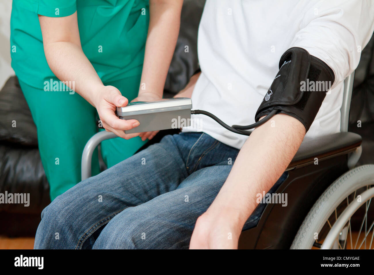 Blood pressure check for young man in wheelchair Stock Photo