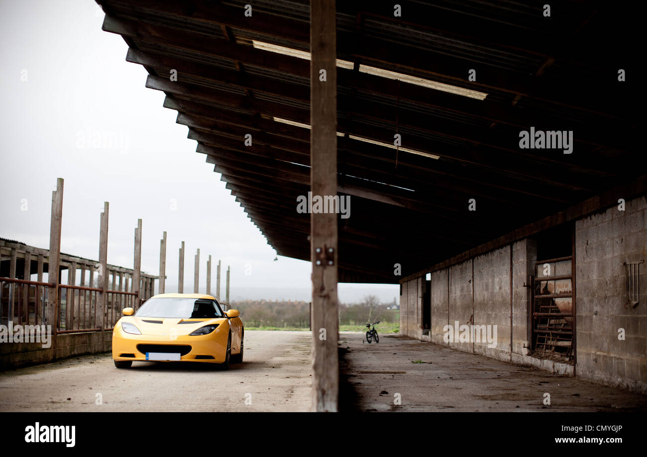 Yellow Lotus Evora sports car on a farm in England, UK. The fast two seater supercar is made in Norfolk. Stock Photo