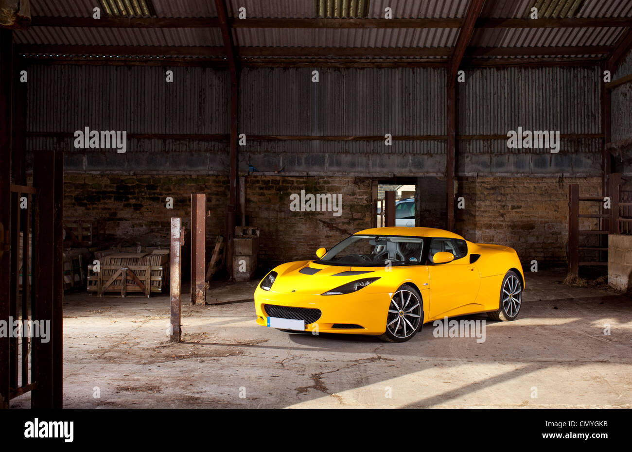 Yellow Lotus Evora sports car on a farm in England, UK. The fast two seater supercar is made in Norfolk. Stock Photo