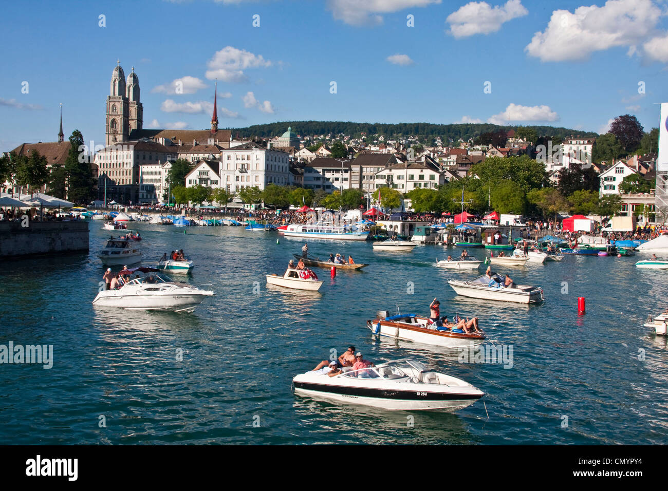 Zurich street parade weekend  in summer, party boats on river Limmat, background  Grossmunster, Zurich, Switzerland Stock Photo